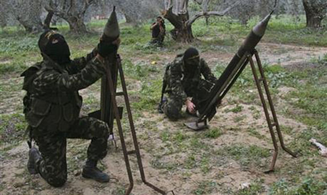 In this December 20, 2008, file photo, masked Palestinian militants from Islamic Jihad place homemade rockets before later firing them into Israel on the outskirts of Gaza City. Photo: AP
