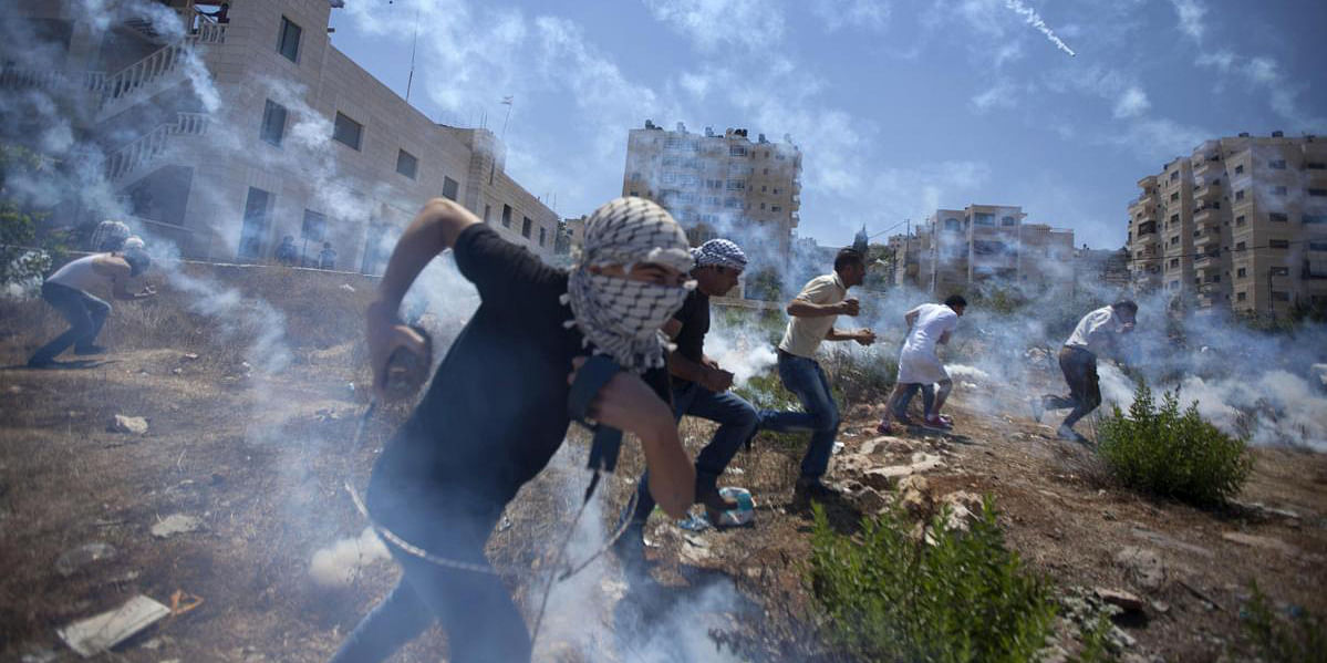 Palestinians run for cover during clashes with Israeli soldiers following a protest against the war in the Gaza Strip, outside Ofer, an Israeli military prison near the West Bank city of Ramallah Aug 1. Photo: AP