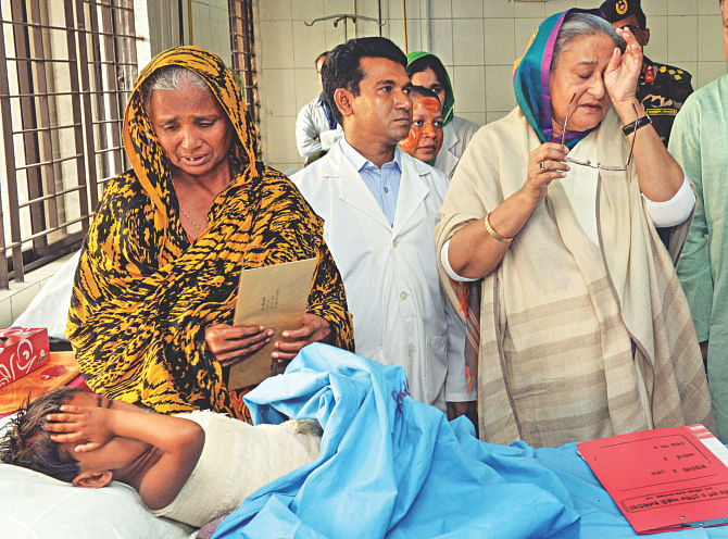 Prime Minister Sheikh Hasina wipes her tears as does two-year-old Jui Akhter in her bed at the burn unit of Dhaka Medical College Hospital. Hasina visited victims of recent arson attacks there yesterday. Photo: BSS