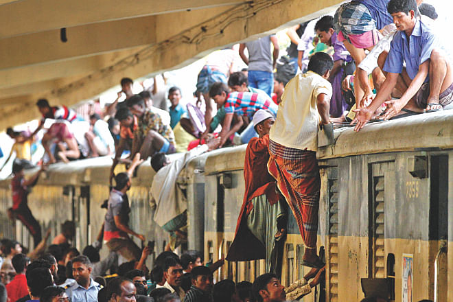 People heading home for the holidays scramble on to the roof of a train, failing to find space to stand inside the carriages at Kamalapur Railway Station yesterday. The railway sells a large number of standing tickets especially during the Eid holidays to cope with huge rush. Photo: Palash Khan