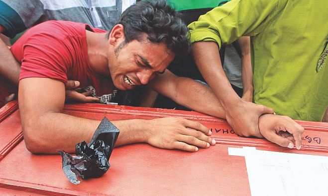 Shah Poran breaks down in tears holding the coffin of his brother Selim at Hazrat Shahjalal International Airport in the capital where his body arrived along with five other corpses yesterday. Nine Bangladeshi workers were killed in a factory fire in Saudi Arabia on May 12. Six bodies were flown home on a Biman Bangladesh flight yesterday. Photo: Star