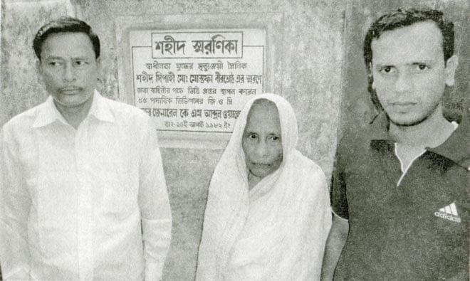 Bir Sreshtho Muhammad Mustafa's mother, brother (L) and nephew in front of the memorial plaque.