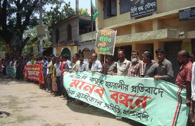 Port users of Hili Land Port form a human chain in front of the customs office at Hakimpur in Dinajpur yesterday to press their three-point demand. Photo: Star