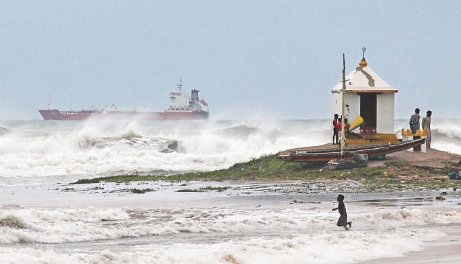 Indians taking precautionary measures as large waves hit the beach ahead of Cyclone Hudhud making expected landfall in Visakhapatnam, yesterday. About 150,000 people were evacuated on India's eastern seaboard yesterday as the cyclone bore down and grew in sheer force, threatening to devastate farmland and fishing villages when it hits the coast today morning. Photo: AFP