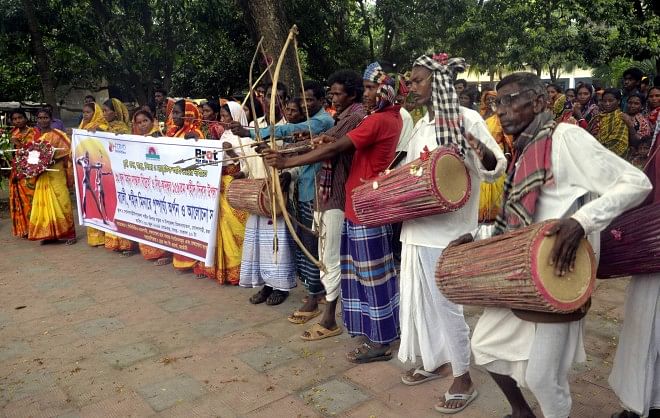 Indigenous people belonging to Santal community perform archery during their traditional cultural programme in Godagari upazila headquarters under Rajshahi district yesterday, marking 159th anniversary of the Santal Hul, an anti-British uprising by the community.   PHOTO: STAR