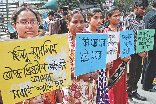 Social Improvement Society forms a human chain in front of Jatiya Press Club in the capital yesterday protesting the barbaric attacks on Hindus across the country. A participant holds a placard saying, 