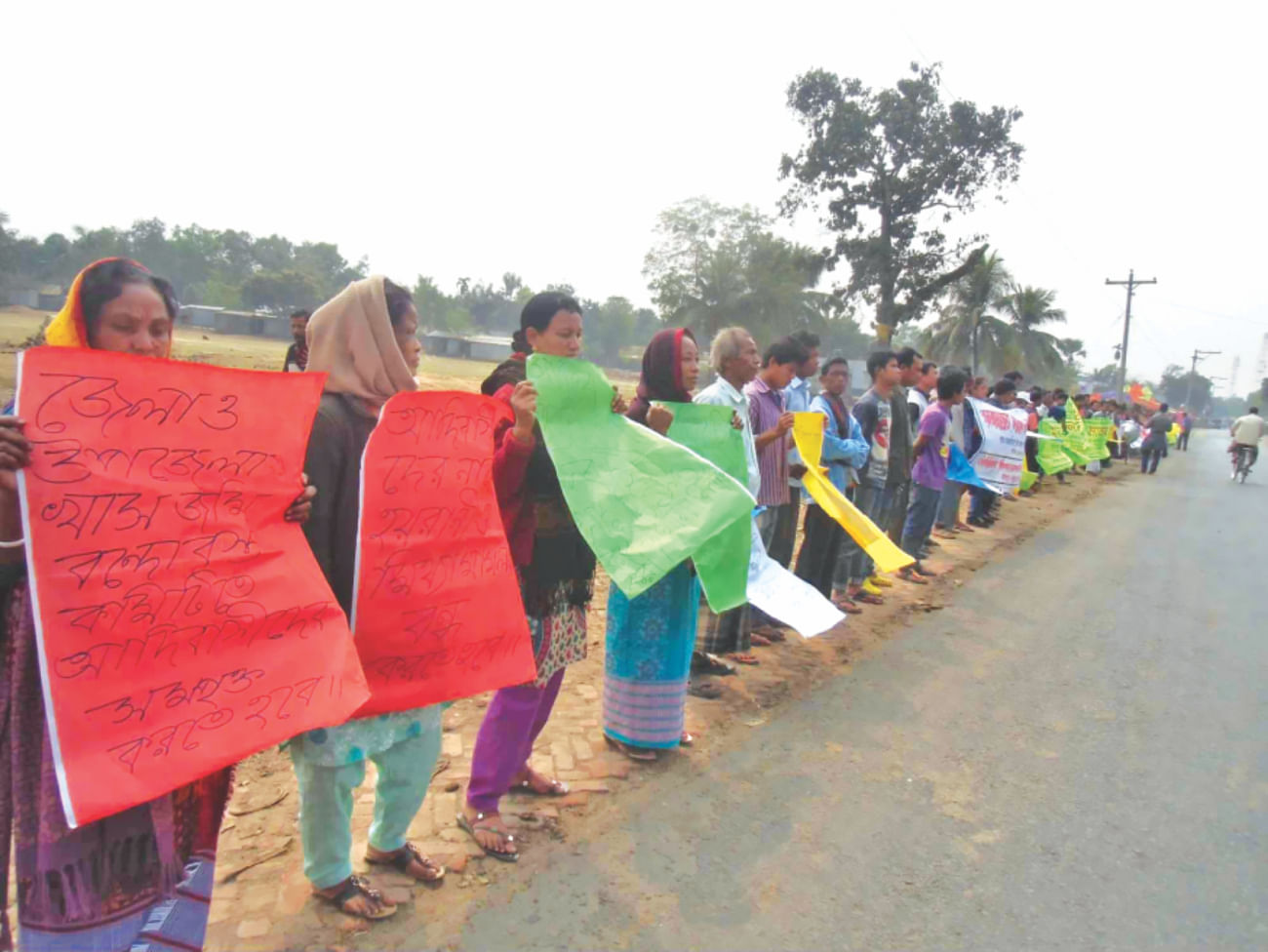 Indigenous people form a human chain at Jalchhatra in Madhupur upazila under Tangail district yesterday demanding proper steps for ensuring legal ownership of their land and withdrawal of 'false' cases filed against them. PHOTO: STAR