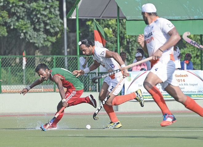 A Bangladesh player (L) attempts to thwart an Indian attack during their second match of the three-match series at the Bangladesh Krira Shikkha Protishthan turf yesterday. The hosts lost the match 1-5. PHOTO: STAR