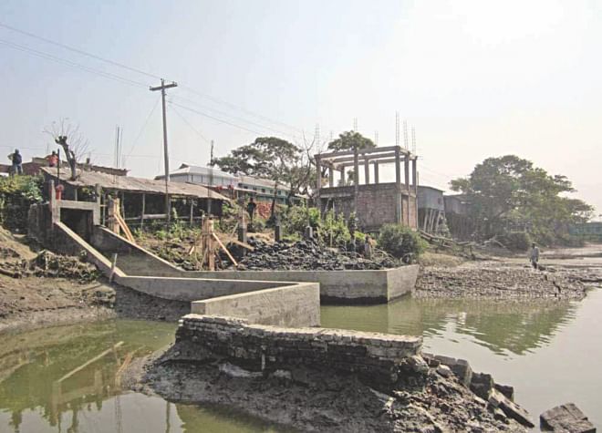 A section of local influential people continue to occupy land and erect permanent structures around a sluice gate at Bablatala Bazar in Kalapara upazila of Patuakhali, much to the worry of the farmers there. PHOTO: STAR