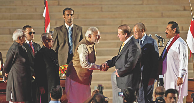 Narendra Modi, after his swearing-in ceremony at the Presidential Palace in New Delhi yesterday, shakes hands with his Pakistani counterpart Nawaz Sharif as Sri Lankan President Mahinda Rajapaksa looks on.   Photo: AFP