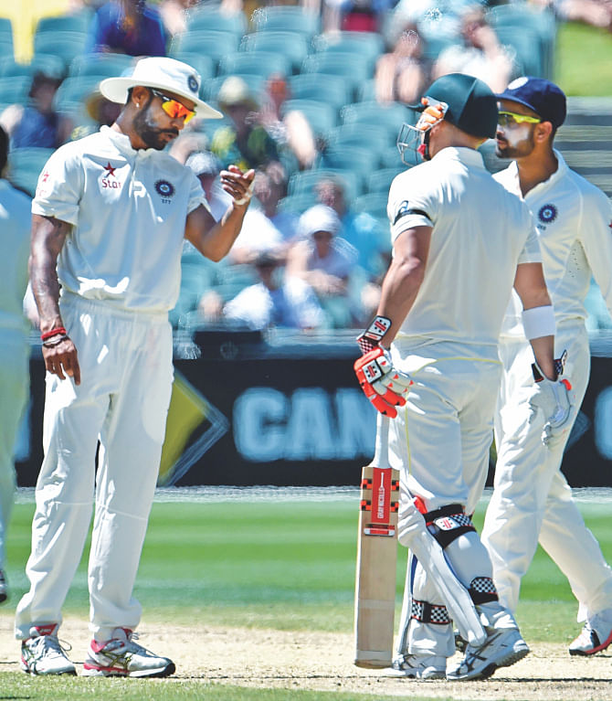 India batsman Shikhar Dhawan (L) exchanges a few heated words with Australia opener David Warner during the fourth day's play of the first Test in Adelaide. There were a couple of such tensed moments yesterday and at one point the umpires had to intervene. PHOTO: AFP