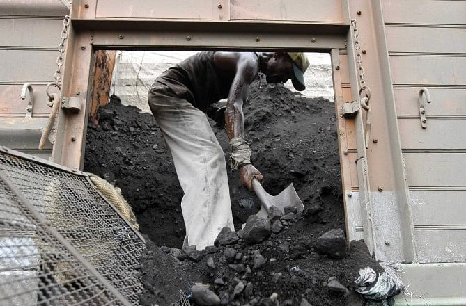 A labourer unloads coal from a supply truck at a yard on the outskirts of the western Indian city of Ahmedabad. Photo: Reuters
