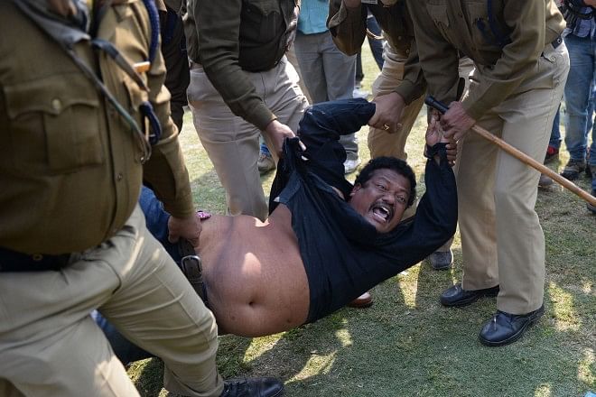 A demonstrator demanding a separate state of Telangana is detained by policemen outside the parliament building. Photo: AFP