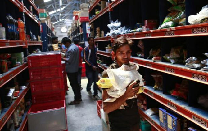 An employee carries goods at a Big Basket warehouse on the outskirts of Mumbai.  Photo: REUTERS/File