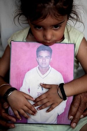  A child holds a portrait of her father in Jammu yesterday, after news that her father was among 40 Indian workers taken hostage in Iraq. Photo: AFP