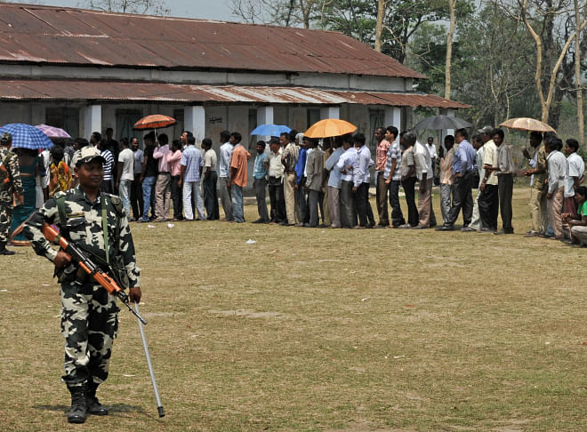 An Indian para-military trooper stands guard as residents queue at a polling station in Siliguri during national elections yesterday. Photo: AFP