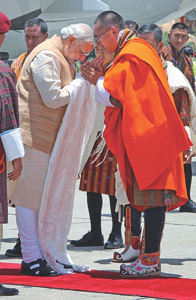 Indian Prime Minister Narendra Modi gestures as he is met by Bhutanese Prime Minister Tshering Tobgay (R) at Paro Airport, yesterday.  Photo: AFP