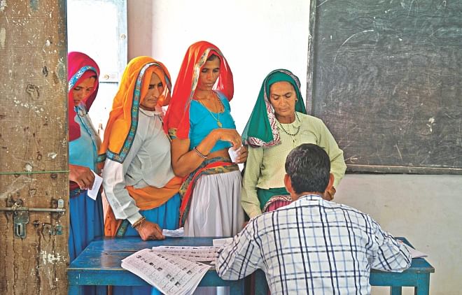 Indian women queue to cast their vote at a polling booth in Alwar. Photo: AFP