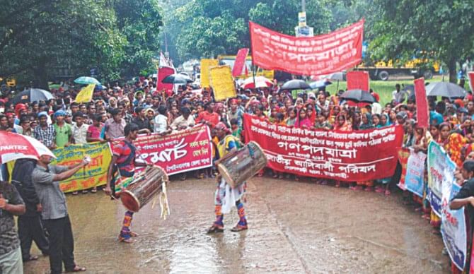 Indigenous people hold a gathering in front of the deputy commissioner's office in Chapainawabganj town yesterday demanding arrest and punishment of the land grabbers who raped a woman indigenous leader in Gomostapur upazila under Chapainawabganj district on August 4. They also reiterated their demand for formation of a separate land commission for the plain land indigenous people in different areas of the country.   PHOTO: STAR