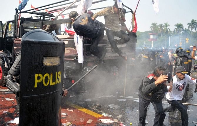 Indonesian anti-riot police move in to arrest supporters of presidential candidate Prabowo yesterday as they try to pass a blockade near the constitutional court in Jakarta.  Photo: AFP