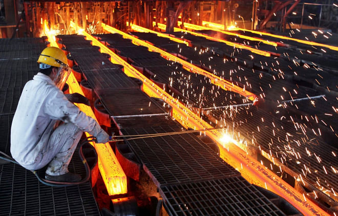 A worker cuts steel bars at a steel plant in Ganyu, Jiangsu province in China. Photo: REUTERS 