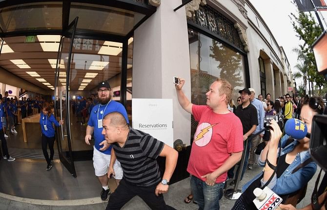 First in line, Francisco Naranjo prepares to rush in as the doors are opened for people waiting to buy the new iPhone 6 and iPhone 6 Plus, at the Apple store in Pasadena, California, Friday. The California tech giant has said more than four million pre-orders were received in the 24 hours after the sale of the new devices was announced. Photo: AFP
