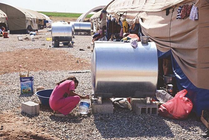 One of the Yazidi girl's is pictured gathering water for her family living within the enclave. At least 20,000 civilians, most of whom are from the Yazidi community, besieged by jihadists on a mountain in northern Iraq have safely escaped to Syria and escorted by Kurdish forces back into Iraq, officials said.  Photo: AFP