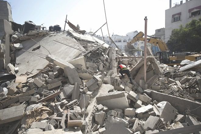 Palestinian Civil Defence workers search for survivors amidst the rubble of a building destroyed in an Israeli air strike, in Gaza City. Photo: AFP