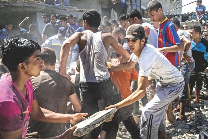 Palestinian men gather and remove the rubble of a house hit by an Israeli airstrike in the al-Shati refugee camp in Gaza City trying to look for survivors. Photo: AFP