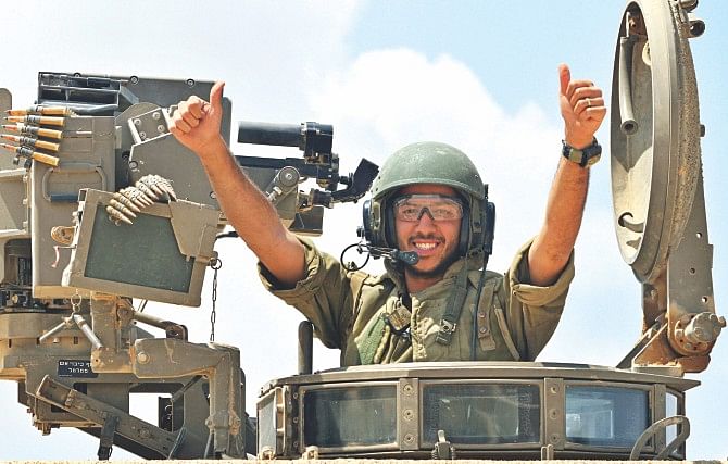 An Israeli soldier celebrates atop an armored personnel carrier as they return from the border between Israel and the Gaza Strip after pulling out of the Palestinian enclave. Photo: AFP