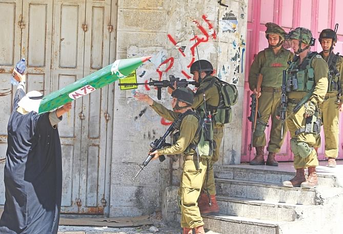 A Palestinian man in the West Bank town of Hebron confronts Israeli soldiers during clashes following a demonstration is support of Gaza after Friday prayers. Photo: AFP