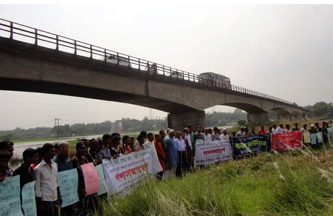 Locals form a human chain under Jagir Bridge in Manikganj Sadar upazila yesterday, demanding immediate steps to save Dhaleswari River from pollution and encroachment. They also demanded massive excavation at Tilli point of the river for its smooth flow.  Photo: Star