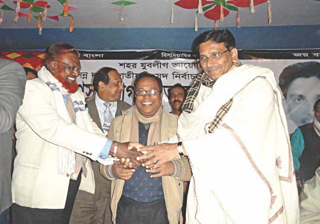 Nawsher Ali, left, who claimed to have defected from Jamaat-e-Islami as its district unit rokon, shakes hand with senior Awami League leader Mahbubul Alam Hanif at a campaign rally for Hanif in Housing area of Kushtia district town on Monday night. Photo: Star