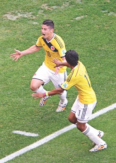 Colombia midfielder James Rodriguez (L) celebrates with teammate Juan Guillermo Cuadrado after scoring the opener against Ivory Coast during their World Cup Group C match at the Mane Garrincha National Stadium in Brasilia yesterday. PHOTO: AFP