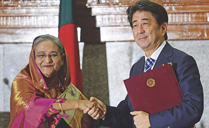Prime Minister Sheikh Hasina and her Japanese counterpart Shinzo Abe pose for a photo -- after signing the joint statement on the latter's visit -- at the PMO in Dhaka yesterday.  Photo: AFP