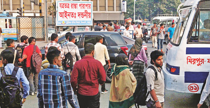 Absolutely ignoring the large sign asking people not to jaywalk, pedestrians cross the Kazi Nazrul Islam Avenue at Sonargaon intersection halting traffic.  Photo: Anisur Rahman