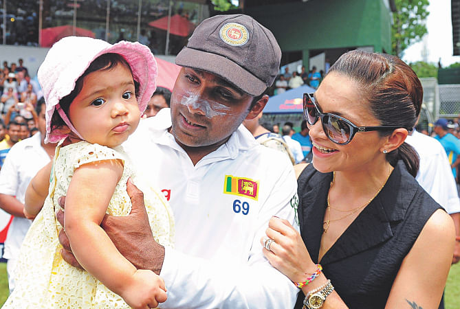 Retiring Sri Lanka batsman Mahela Jayawardene holds his daughter Sansana as his wife Christina Sirisena looks on during the post-match ceremony at the Sinhalese Sports Club ground in Colombo yesterday.  PHOTO: AFP