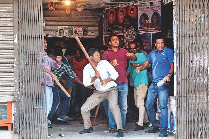 Chased by the agitating faction, followers of new committee leaders take shelter at the BNP headquarters and make gestures welding sticks. Photo: Amran Hossain