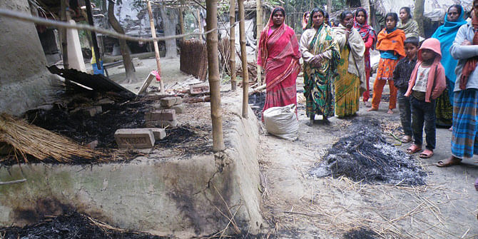 This January 6 photo shows people looking at their burned house in Malopara village of Abhaynagar upazila in Jessore. BNP and Jamaat-e-Islami men torch many houses of the area as the villagers cast their vote during 10th parliamentary election the day before.  