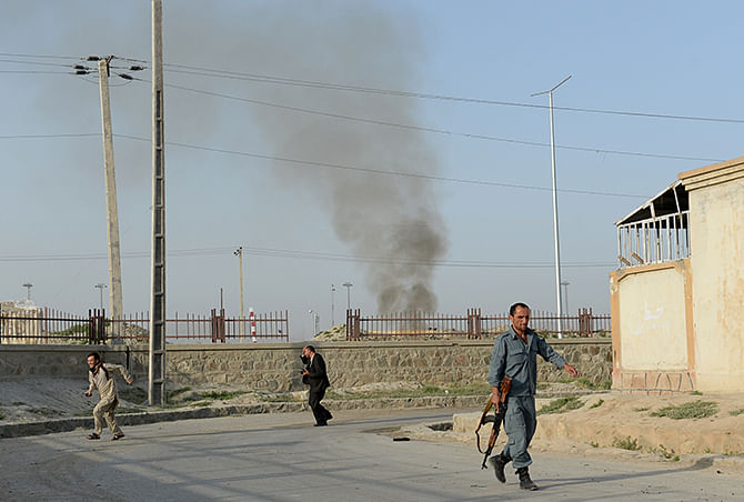 Afghans run for cover at the site of a suicide attack in front of Kabul's military airport on July 17. Explosions and gunfire rang out after the Taliban attacked Kabul airport in the militants' latest brazen attempt to steal the initiative with the country in the grip of a presidential power struggle. Photo: Getty Images