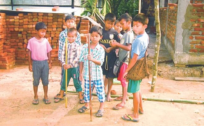 Even little kids, who refrain from classes in fear of attacks on the way to school yesterday, are forced to pick up sticks for self-preservation. Photo: Mintu Deshwara