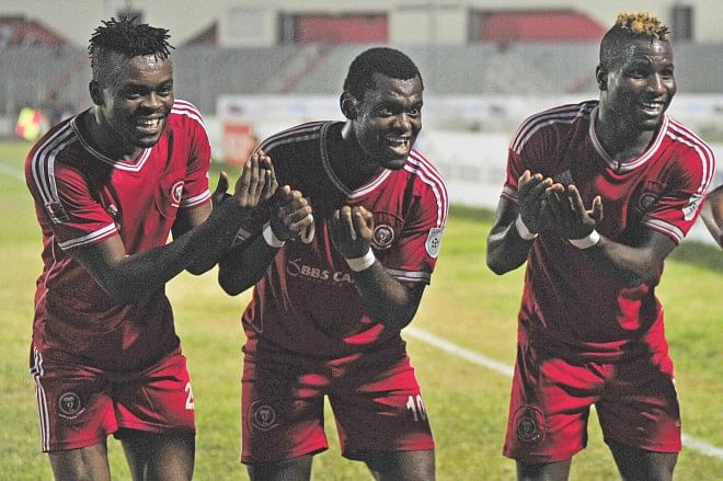 Muktijoddha's Nigerian strikers Eleta Kingsley (C) Nkowcha Kingsley (R) celebrate with compatriot and fellow hitman Sunday Chizoba (L), who became father of his first son on Wednesday, after the latter scored the last goal of his team's 4-2 win over BJMC at the Bangabandhu National Stadium last night. PHOTO: STAR