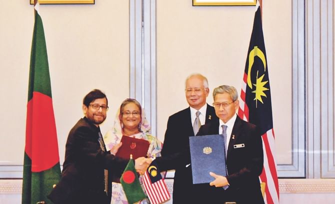 Cultural Affairs Minister Asaduzzaman Noor shakes hands with Malaysia's acting minister for tourism and culture Mustapa Mohamed after signing an MoU on cultural, arts and heritage cooperation in the presence of Prime Minister Sheikh Hasina and her Malaysian counterpart Najib Tun Razak in Putrajaya. Photo: BSS