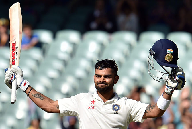 Stand-in India skipper Virat Kohli celebrates his century which led India to a strong position against Australia during the third day of the first Test at the Adelaide Oval yesterday. PHOTOS: AFP