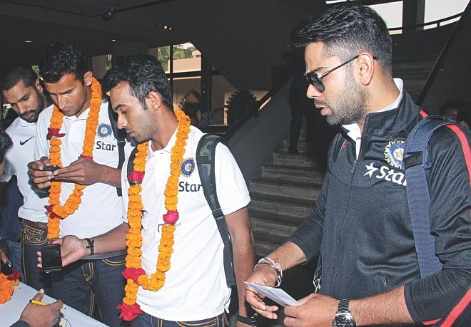 MAY I HAVE THE KEY TO THE CAPTAIN'S SUITE: Virat Kohli (R), who will lead India in the Asia Cup, waits at the check-in counter at the Pan Pacific Sonargaon Hotel yesterday. Photo: Firoz Ahmed