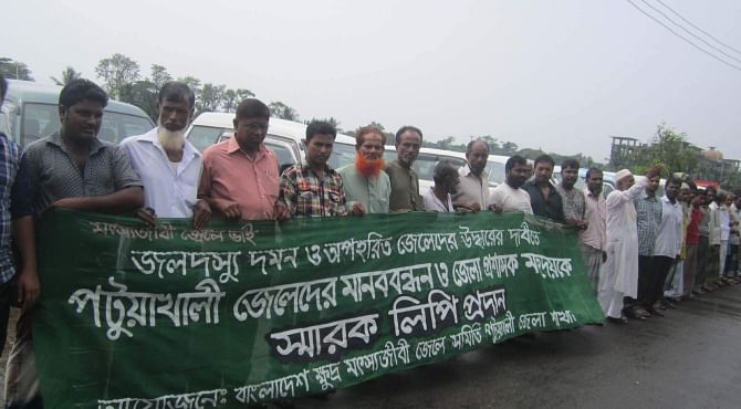 Around 100 fishermen from Kuakata area form a human chain in front of the deputy commissioner's office in Patuakhali yesterday, demanding steps to ensure security of fishermen in the Bay and rescue the fishermen abducted by robbers for ransom.  Photo: Star