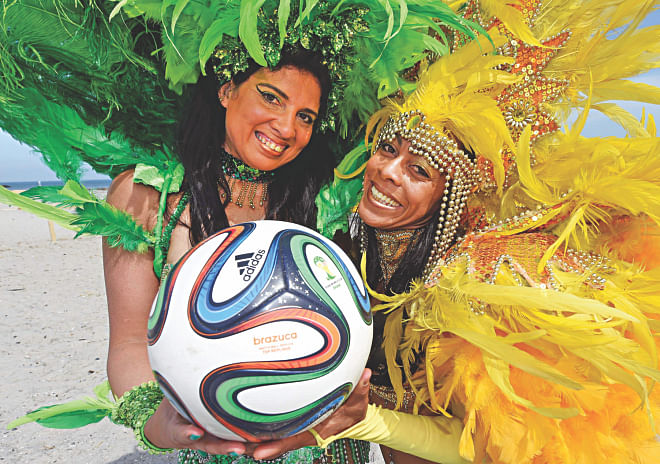 Samba dancers Luciana (L) and Simone display Brazuca, the official match ball of World Cup 2014, on the so-called WC-beach-Brazil in northern German town of Brasilien yesterday. PHOTO: AFP