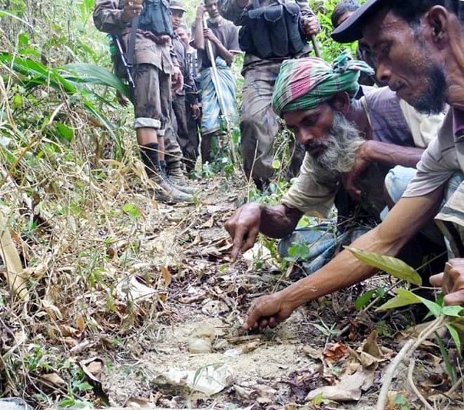 With the help of locals, BGB members remove landmines buried by Myanmar Border Guard Police at Bangladesh-Myanmar border yesterday. The landmines were buried between 50 and 52 border pillars at Naikkhangchhari in Bandarban. Photo: Banglar Chokh
