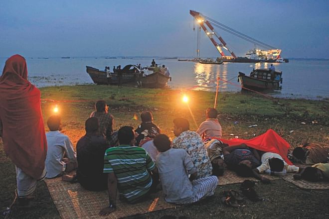 Relatives of those missing in the capsize of MV Miraj-4 wait on the shore in the early hours yesterday as rescue vessel Prattay tries to salvage the launch at Daulatpur of Gazaria in Munshiganj. Photo: Courtesy