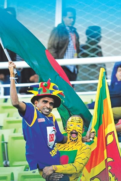 A brilliantly painted Tigers fan lifts a Sri Lankan supporter up at Mirpur yesterday. Ironically, the Tigers on the field also helped out the Lankans to an improbable victory in the 1st  ODI with their poor batting performance. Photo: Firoz Ahmed